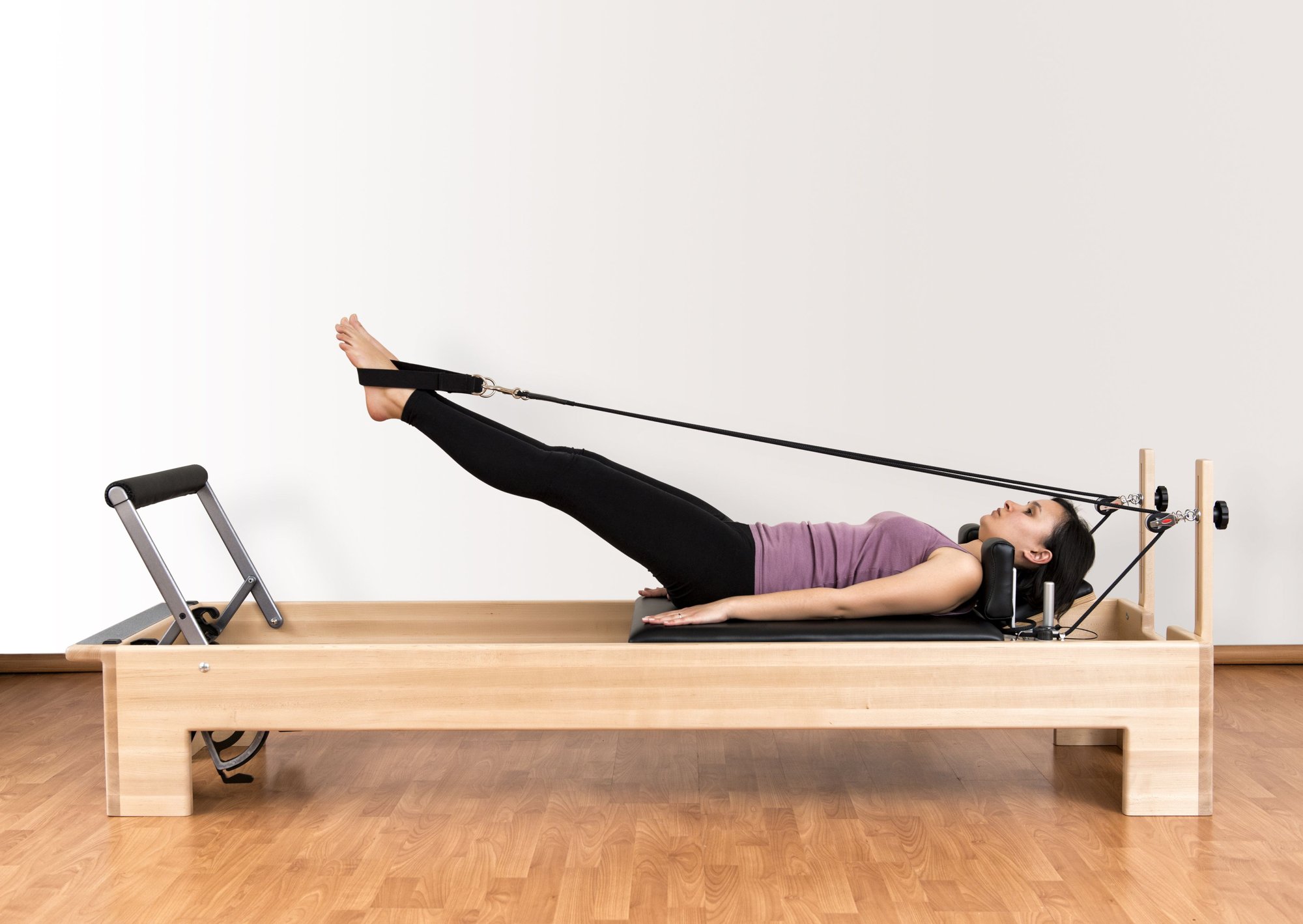 Leg-strap work lying on the Pilates reformer